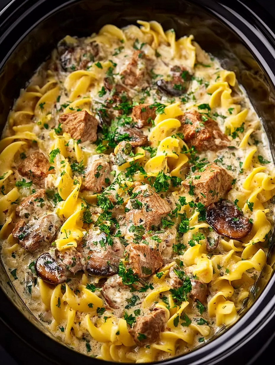 A bowl of pasta with meat and mushrooms.